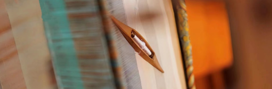Close-up of a sewing needle with fabric background